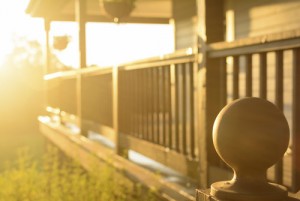Afternoon rays of sun against a wooden porch