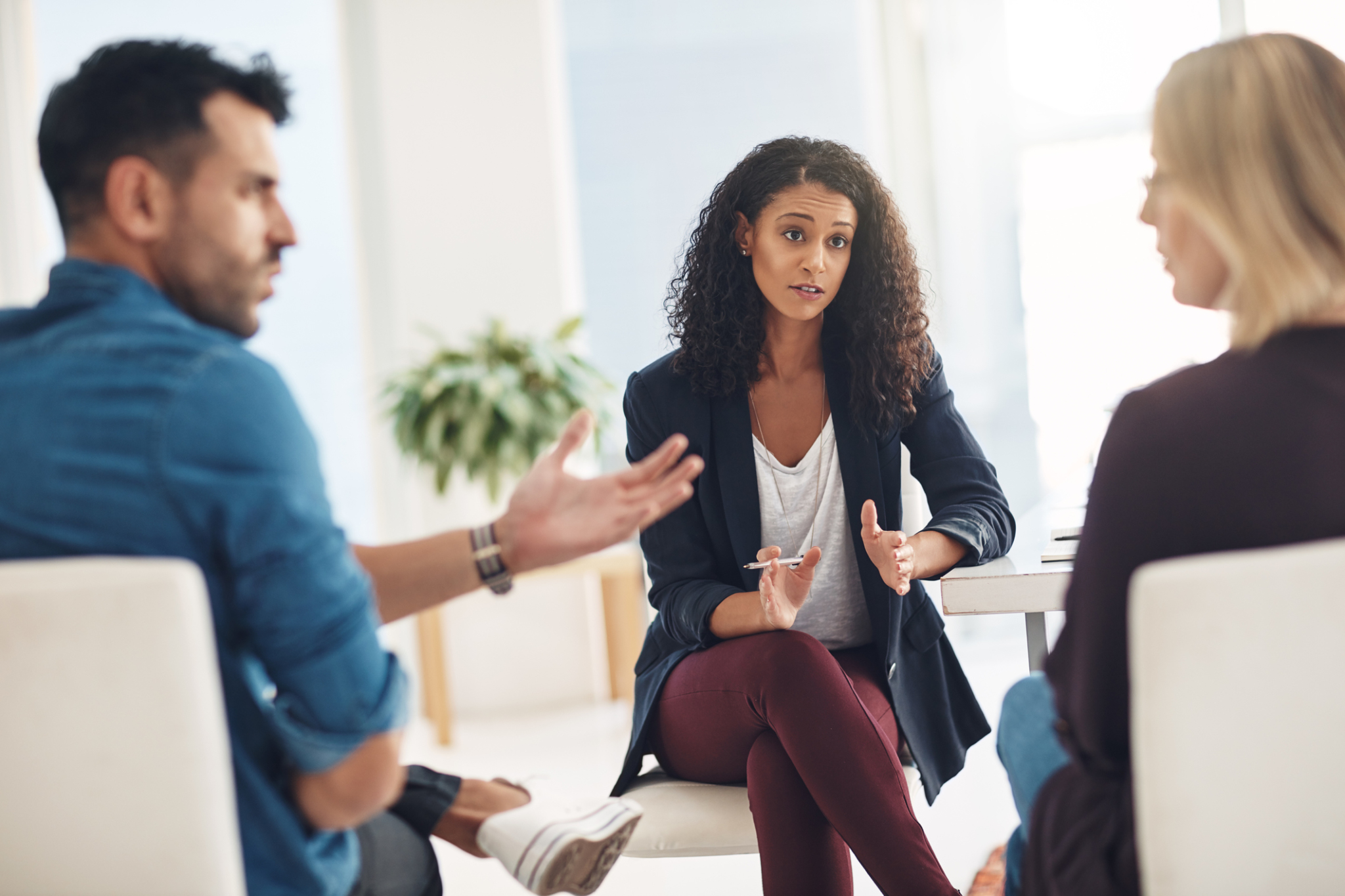 woman mediates an argument between two other people