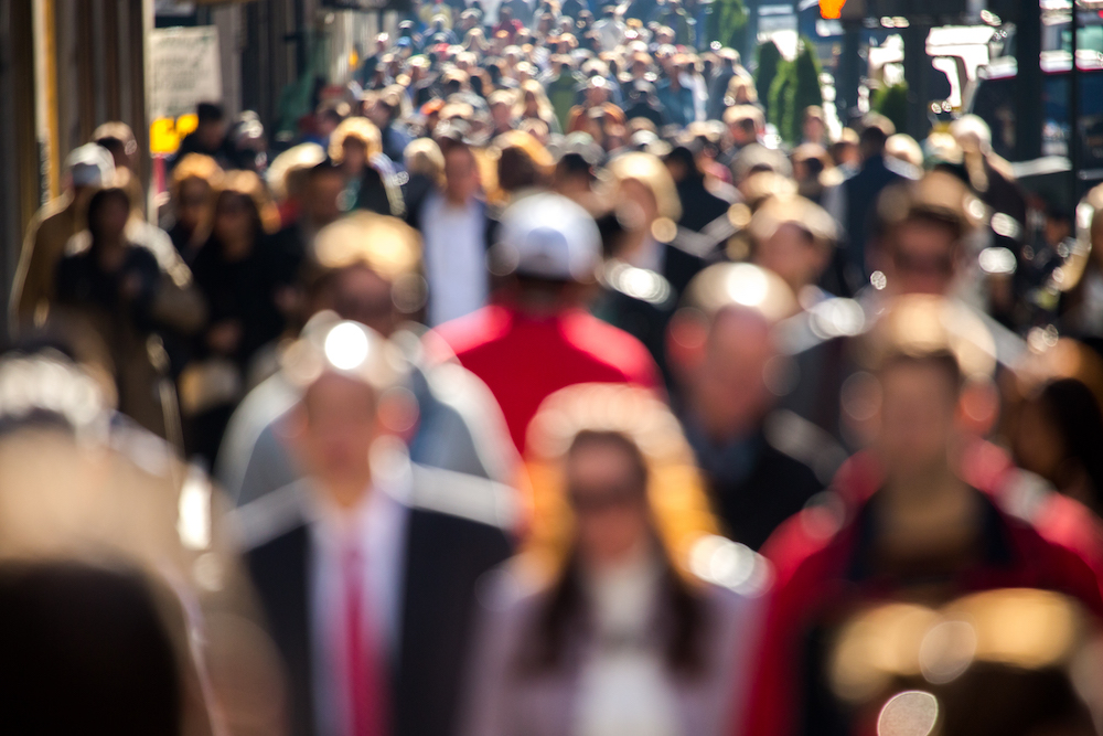 Anonymous crowd of people walking on New York City street sidewalk