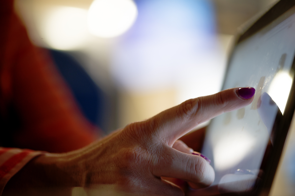 A woman uses a touch screen device.